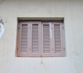 Window closed shutters on the wall of a house