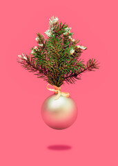 Christmas silver ball tree with shadow and beige champagne ribbon color. Franch rose background with copy space. The holiday season and natural green pine branches with the snow.