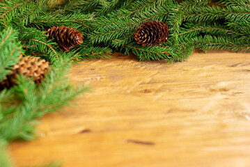 Branches of a Christmas tree and cons on a brown wooden background. Close-up, place for text, layout for design