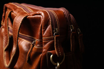 Men's bag made of genuine orange leather on a dark background.