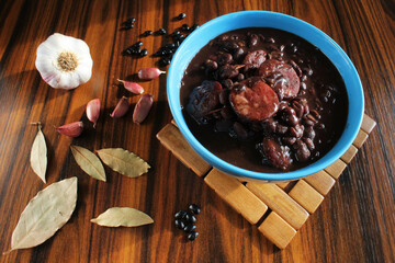 Brazilian food. Bowl with traditional dish called 'Feijoada' made with black beans and pork meat. Seletive focus.