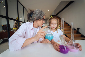 Attentive old grandma assist grandkid in funny scientific research