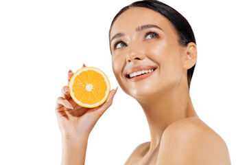Woman and fruit portrait. A happy model holds a juicy orange near her face and looks at the camera on a white background