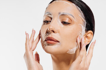 Beautiful young shirtless woman posing with cosmetic facial mask, Woman with moisturizing sheet...