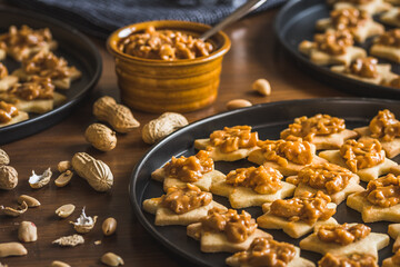 Homemade star shaped cookies with peanut caramel topping on wooden background