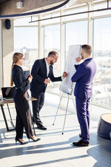 Business professionals. A group of young successful business people are analyzing data using graphs while spending time in a new modern office.