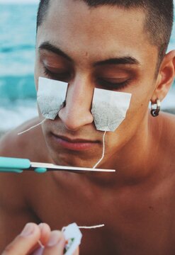 portrait of young man with teabags on face to cry tears that taste good