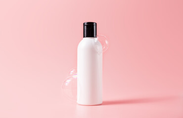 Shampoo bottle with soapy bubbles. Plastic white packing with black cap beauty skincare cosmetic packaging mockup