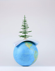 Green movement ecology concept: a globe, a mock-up of the earth, a decorative tree, a bundle of paper. 