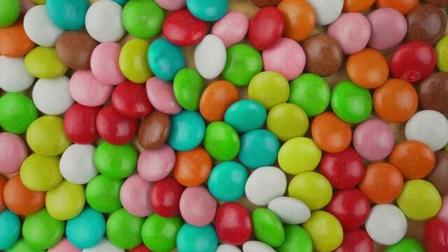 Background of multi colored sweet candy assorted on table or plate surface top view. Caramel and chocolate food for children and baby.