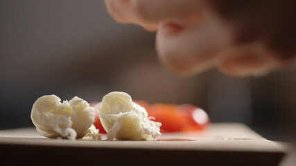 man tear mozzarella cheese on olive wood board closeup