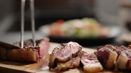 man cut fat from new york steak on olive wood board