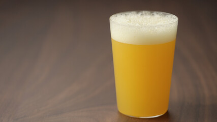 pour yellow drink in tumbler glass closeup