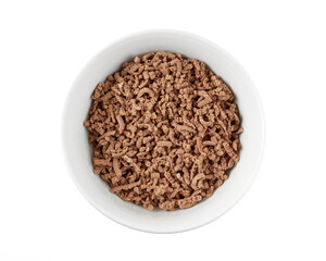 Chopped boiled beef. Chopped meat in a white plate. The plate is located in the lower left corner. The plate is not completely visible. View from above. White background