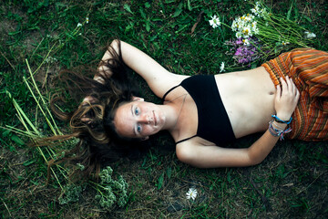 Girl lying on green grass, shot from above.