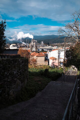 Smoke from the chimneys of a factory in an old town in Galicia, Spain.
