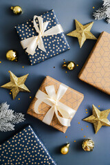 Vintage Christmas gift boxes, golden stars and baubles on blue background. Christmas vertical composition. Flat lay, top view.