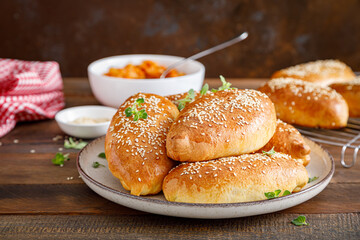 Homemade baked pies or patties stuffed with cabbage on wooden background