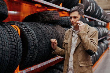 Fototapeta na wymiar man customer choosing new tires in the auto shop