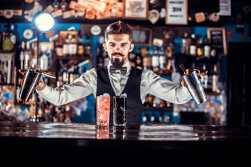Experienced bartending adds ingredients to a cocktail in the pub