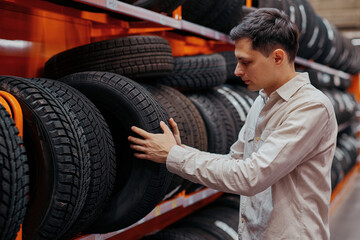 Obraz na płótnie Canvas male customer choosing new tires in the supermarket .