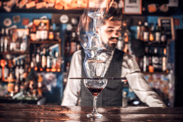 Professional bartender places the finishing touches on a drink at bar