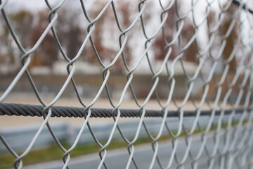 Metal fence close up. Security and safety concept. Metallic wire barrier. Iron boundary. Steel gate. Protection concept. Criminal cage. Industrial architecture.