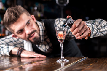 Charismatic bartending decorates colorful concoction in the pub