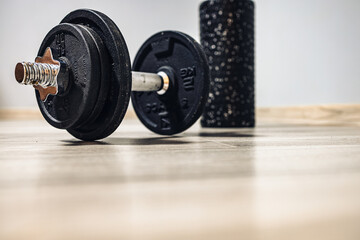 a dumbbell for exercises and a back roller waiting for training. home fitness and motivation . no person 