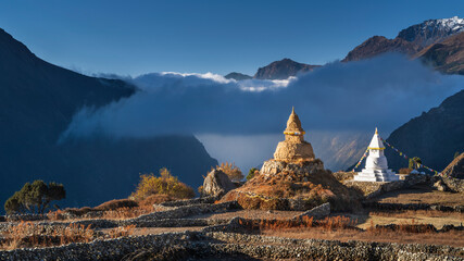 View to two old buddha stupa in village in Nepal in sunset tie with clouds in valley and with copy...