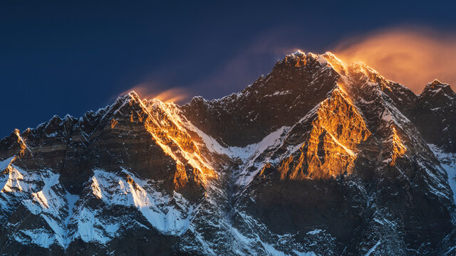 Fototapeta first sun lights on the peaks of Lhotse and Nutse under blue sky in Nepal