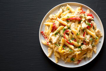 Homemade One Pot Chicken Fajita Pasta on a Plate on a black background, top view. Copy space.