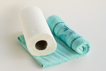 Clean face towel in blue color with paper towel on white background