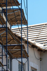 scaffolding made of metal profile and wooden decking along the building during the renovation. Restoration of an old building in the historical center of the city. Repair of the roof and facade.