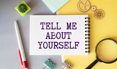 text TELL ME ABOUT YOURSELF on white noteboock