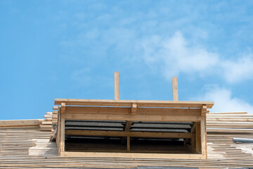 View of the frame of a new wooden roof made of thick beams. Repair of a sloping roof in a country...