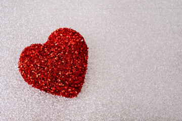 Red glitter heart on silver background. Love concept
