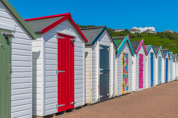 Fototapeta na wymiar Colorful beach houses. Row of multicolored beach huts against blue sky.