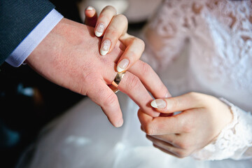 Bride and groom putting on the ring ceremony.