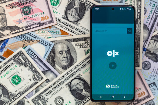 smartphone screen with online marketplace OLX application on US dollar banknotes background
