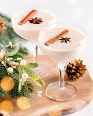 Eggnog on wooden tray, Christmas cocktail in coupe glass, top view