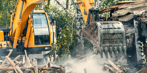 Demolition of old house. Excavator breaks building for new housing.
