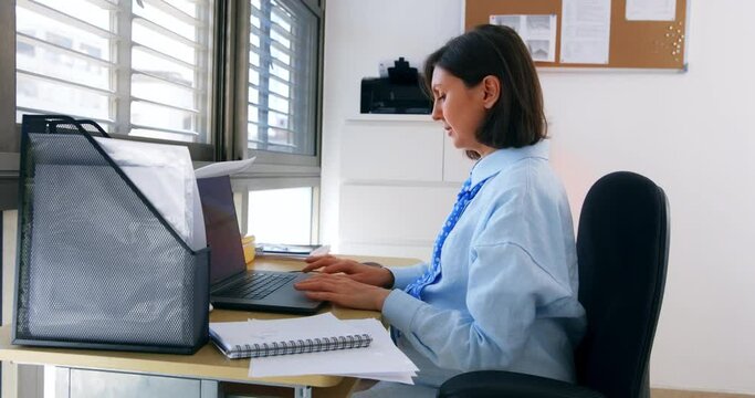 pregnant woman works in the office at a table by the window and has lunch at her workplace during a break. High quality 4k footage