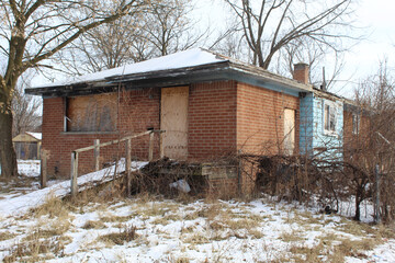 Abandoned brick ranch home with wheelchair ramp in winter in Detroit's Franklin Park neighborhood
