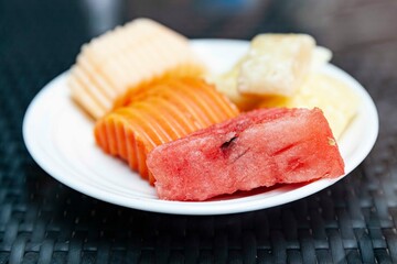 Mixed fruit plate on white brown table