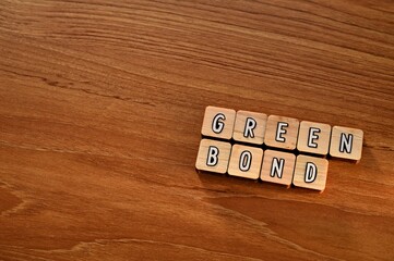 The letters arranged in the word Green Bond. It's on a wood board.