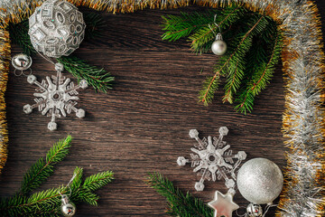 Christmas Tree Branches and Snowflakes on a Brown Background with Copy Space
