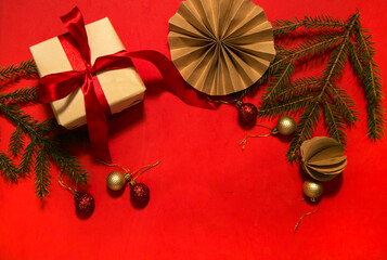 christmas background with fir branches and balls on red background