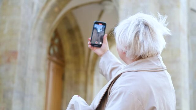 plump woman takes pictures of the cathedral church on the phone