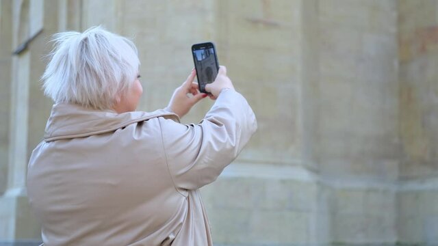 plus size blonde woman takes pictures of the old church